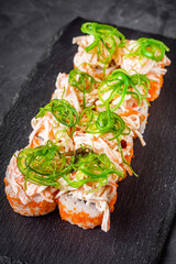 delicious sushi rolls on a black stone background