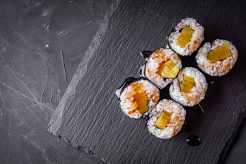 delicious sushi rolls on a black stone background