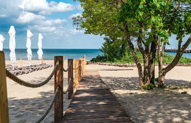 Wooden walkway on sunny sandy beach - obrazy, fototapety, plakaty