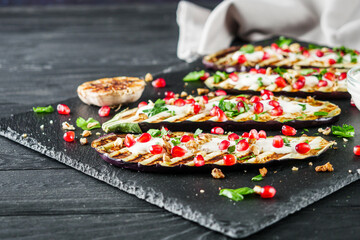 grilled eggplant in Georgian style on a black dark wooden rustic background
