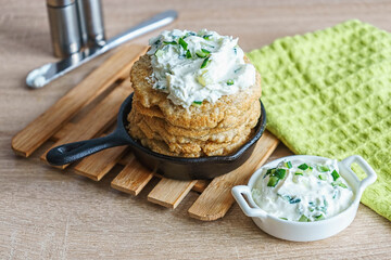 Oatmeal fritters with soft curd sauce with cucumber and herbs