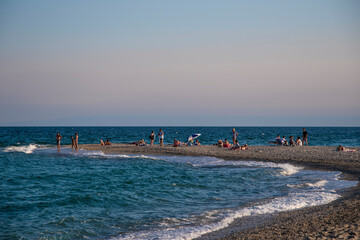 Beautiful view of iconic Posidi sandy beach, paradise cape and Peninsula in Kassandra, Halkidiki, North Greece. People walking, swimming and sunbathing on sea beach.