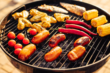 Assorted delicious grilled meat with grilled vegetables, barbecue with smoke and flame