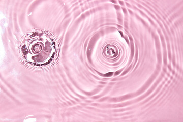 Splashes of water on a pink background, top view. Background for your design.