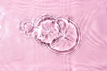 Splashes of water on a pink background, top view. Background for your design.