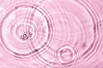 Splashes of water on a pink background, top view. Background for your design.