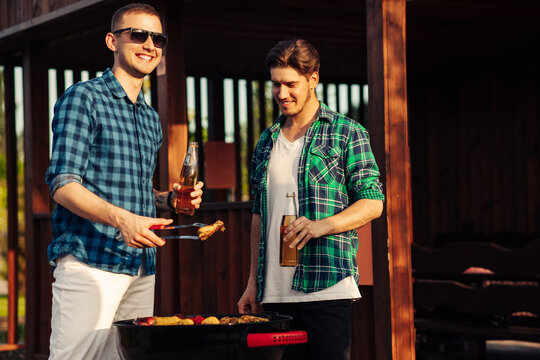 Happy Friends Cooking Barbecue Grilled Meat And Drinking Drinks At Outdoor Summer Party, Happy Men Cooking Barbecue