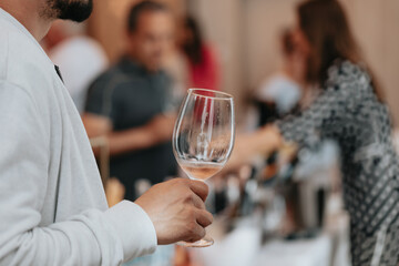 We celebrate success with a glass of rose wine in hand at a special tasting with happy people.