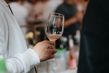 We celebrate success with a glass of rose wine in hand at a special tasting with happy people.