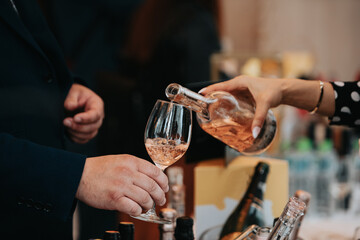 We celebrate success with a glass of white wine and champagne in hand at a special tasting with happy people.