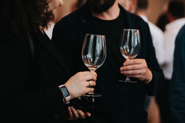 We celebrate success with a glass of rose wine in hand at a special tasting with happy people.