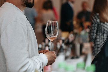 We celebrate success with a glass of rose wine in hand at a special tasting with happy people.