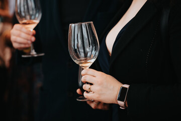 We celebrate success with a glass of white wine and champagne in hand at a special tasting with happy people.