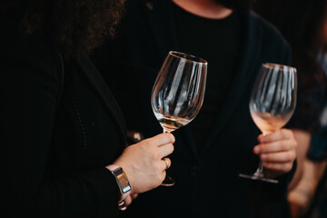 We celebrate success with a glass of rose wine in hand at a special tasting with happy people.