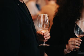 We celebrate success with a glass of rose wine in hand at a special tasting with happy people.