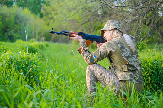 Ukrainian female soldier armed with an assault rifle patrols a combat zone