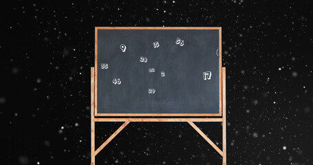 Image of numbers moving over blackboard on black background