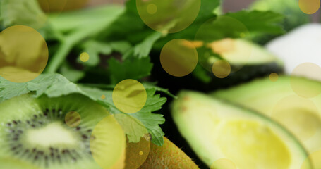 Image of falling yellow spots over fruits