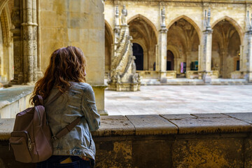 Woman contemplating the Gothic cloister of the Unesco cathedral in the city of Leon, Spain.