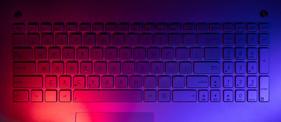 laptop computer keyboard with neon lights. top view