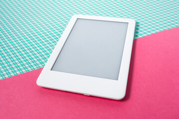 Ebook reader on the striped green background with pink