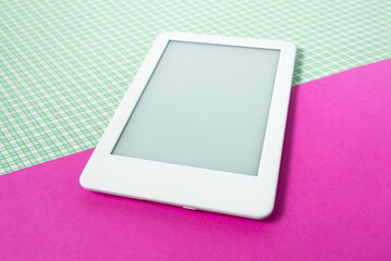 Ebook reader on the striped green background with pink