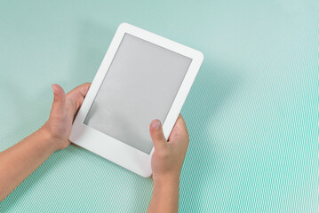 Ebook reader over green background - being held by the hand of a child