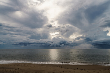 Rainstorms are forming under the clouds in the middle of the sea approaching the coast, a mysterious and fear natural phenomenon at Khao Lak Beach, Phang Nga, Thailand. Leave space for text input.