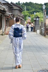 Fototapeta premium 小江戸佐原の町並みを歩く浴衣を着た若い女性の後ろ姿 