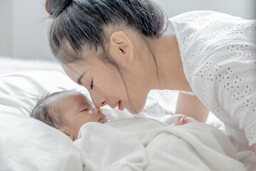 baby sleeps asian mother and touches her child with tenderness and cherishness