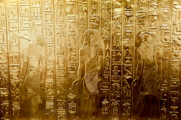 A golden wall with engraved Egyptian gods, the tomb of pharaoh Tutankhamun