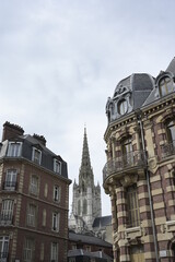 La tour de l'Église catholique Saint-Maclou de Rouen entouré de 2 immeubles.