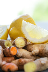 Roots of ginger and turmeric with lemon on plate