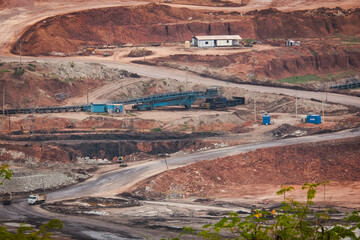 View of Trucks and excavators work in open pits in lignite coal mines. Lignite Coal Extraction Industry. The famous outdoor learning center of Mae Moh Mine Park, Lampang, Thailand.