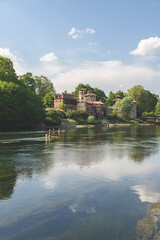 Fototapeta premium View of the Valentino park and the Medieval Village along a bank of the Po river. Turin, Italy. May 1, 2022.