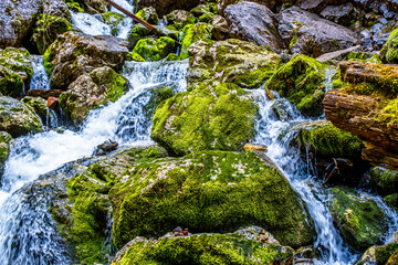 Fresh water flows over rocks & stones down a river bed, in a beautiful nature landscape
