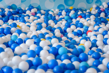 Blue and white plastic balls in ball pit. Indoor children's playground.
