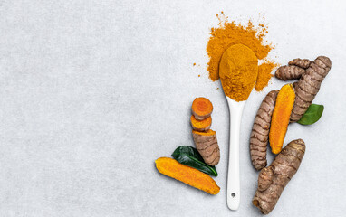 Turmeric powder and fresh turmeric. curcuma or curcumin on concrete background. Spice, natural...