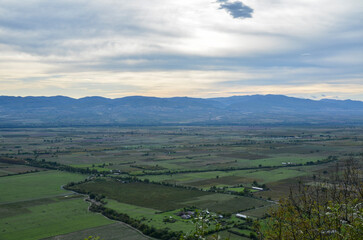 Panoramic view of Alazani valley fields and Caucasus Mountains from the height of the hill, Kakheti region, Georgia 