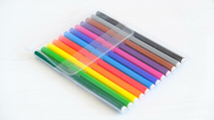Multicolored felt-tip pens in a transparent package on a white background