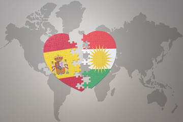 puzzle heart with the national flag of kurdistan and spain on a world map background. Concept.