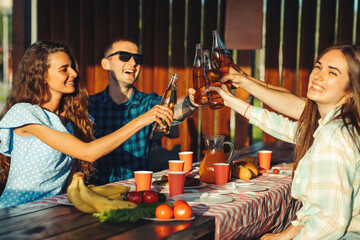people have lunch and have fun together, drink drinks while sitting at a table in nature. friends eating barbecue