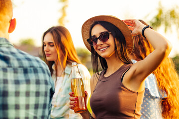 people have a picnic in nature. friends relax and drink drinks. people communicate while sitting on the grass