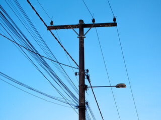 Street light lamp post in Brazil. SDeep blue skies. Lots of wires.