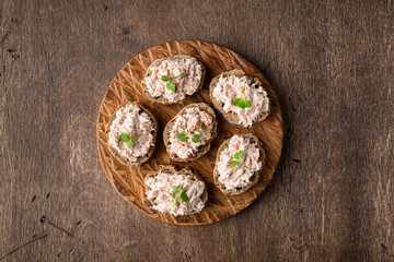 bruschetta with tuna pate, fish rillettes on wooden background, top view, copy space