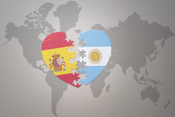 puzzle heart with the national flag of argentina and spain on a world map background. Concept.