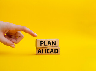Plan ahead symbol. Wooden blocks with words 'Plan ahead'. Beautiful yellow background. Businessman...