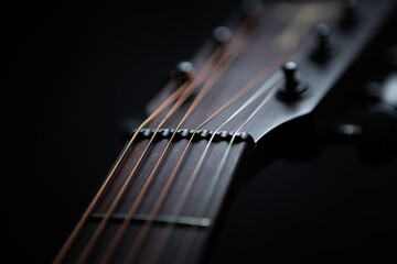 Metal string on guitar neck in closeup. Fingerboard on professional acoustic musical instrument 