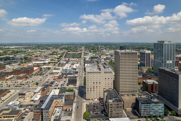 Looking Down a Street Cityscape with Puffy Clouds and a Blue Sky