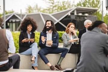 group of business people sitting outdoors resting outdoors - focus on man with leg prosthesis -